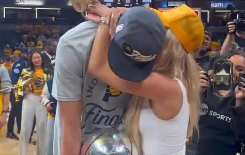 谈球吧官网登录入口人生赢家！哈利伯顿赛后抱着东部冠军奖杯和女友拥抱合照