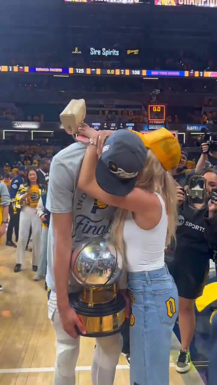 谈球吧官网登录入口人生赢家！哈利伯顿赛后抱着东部冠军奖杯和女友拥抱合照